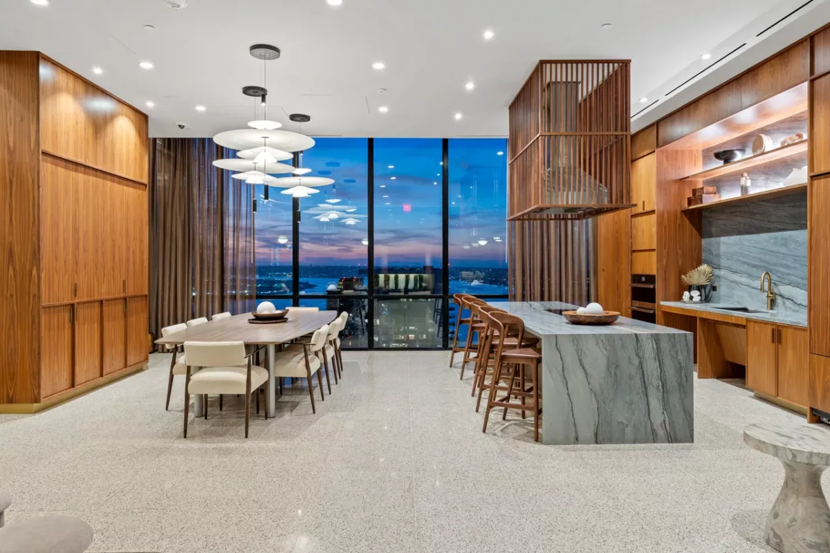 Sky lounge kitchen and dining area at dusk with large windows and modern lighting.
