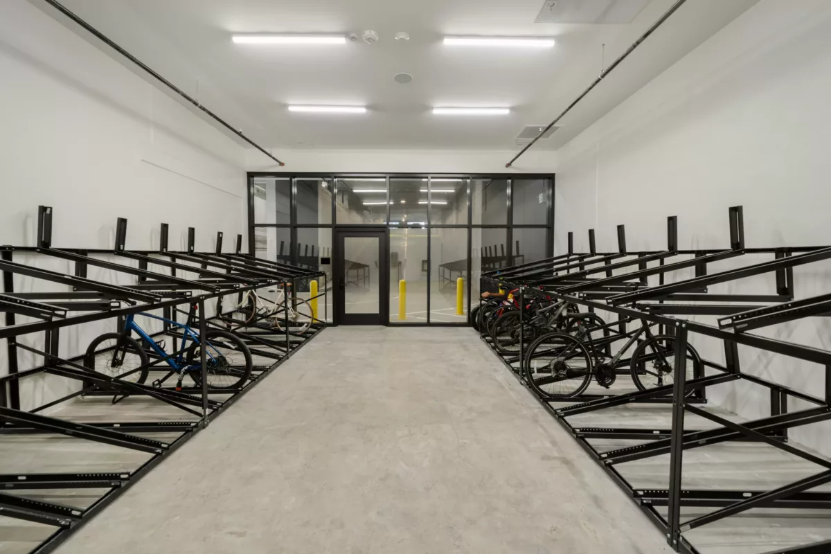 Secure indoor bike storage room with metal racks and multiple bicycles parked.