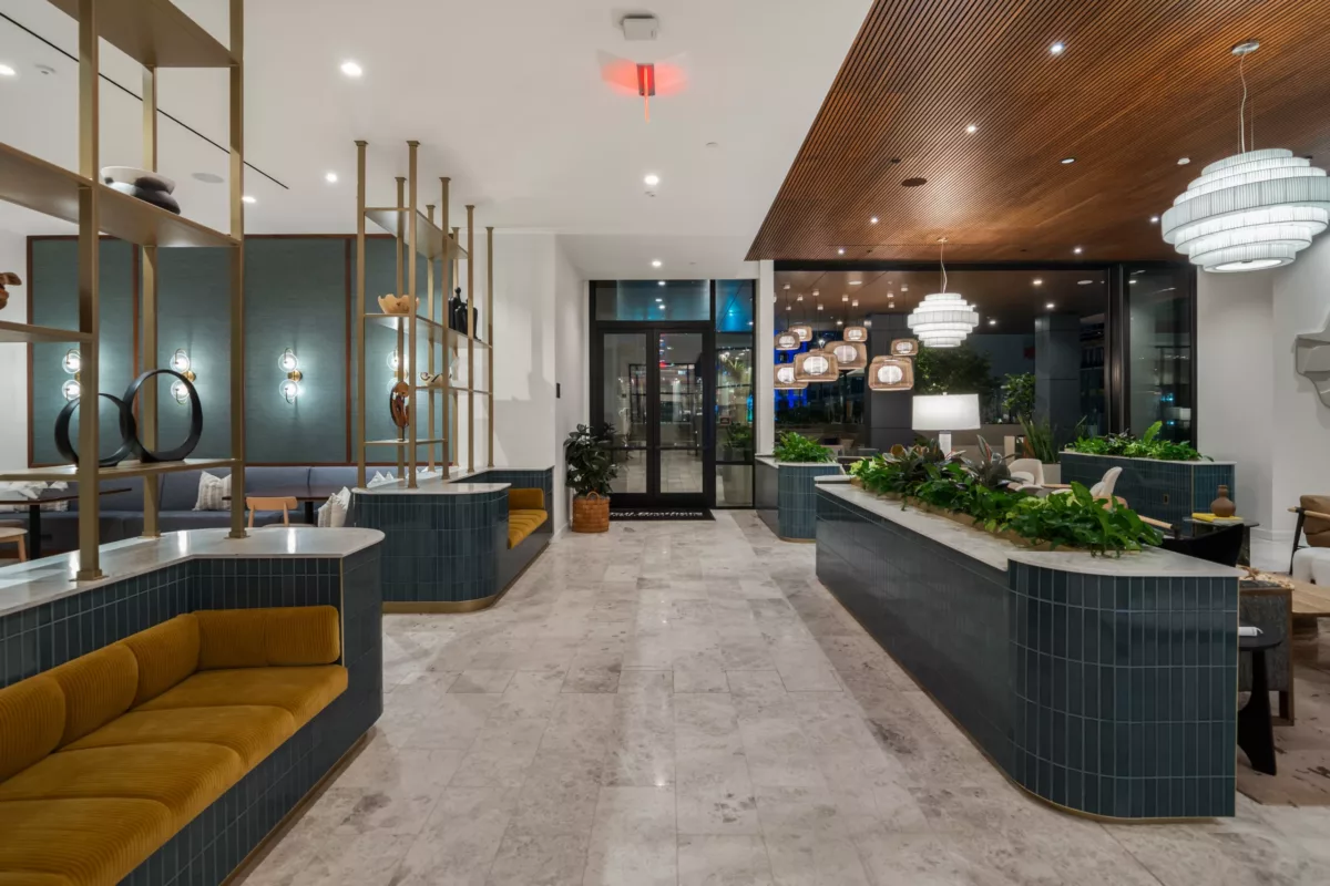 Billiards room with pool table, card table, bar seating, and floor-to-ceiling windows. **Alt Text:** Clubroom at dusk with modern seating, wood ceiling, pendant lights, and built-in booths.