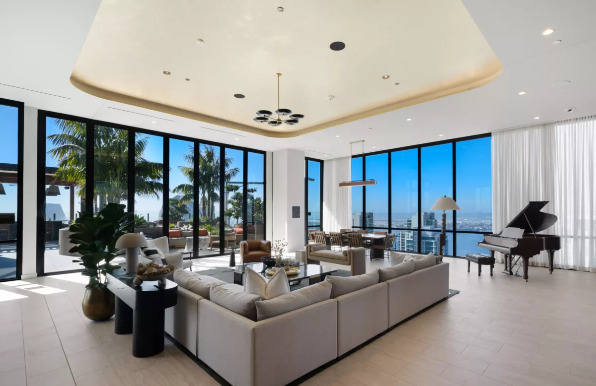 Sky lounge by day with grand piano, dining area, and floor-to-ceiling windows.