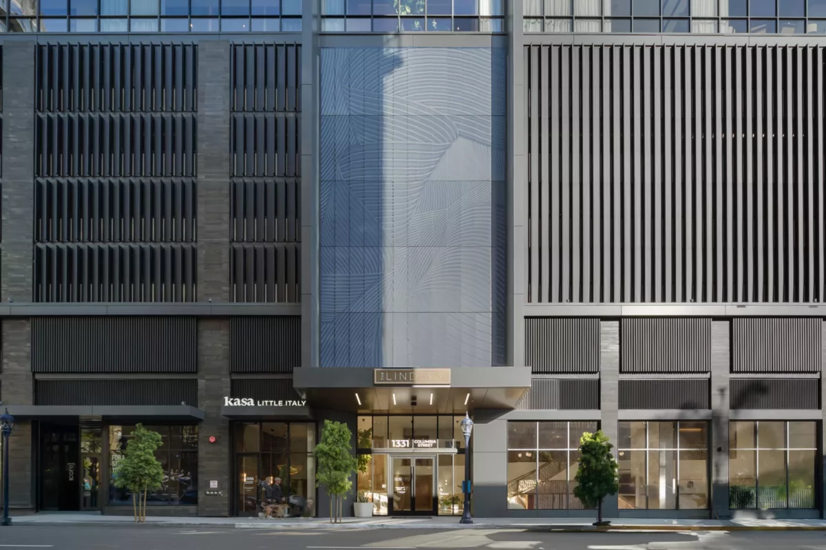 Modern high-rise entrance with "The Lindley" signage and vertical architectural detailing.